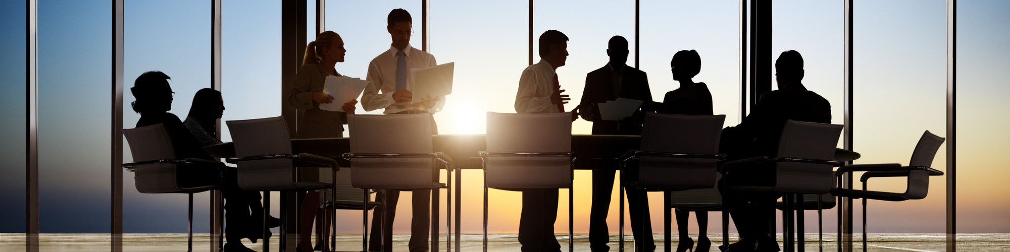 Three men standing up in meeting room 